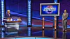 Jeff Rich's contestant photo with Alex Trebek. Alex is at his lectern, Rich is standing well away beside a television screen with the new Jeopardy! logo.